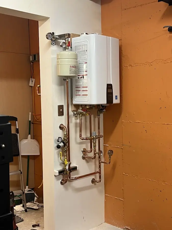 Plumbing technician inspecting water heater connections in La Porte